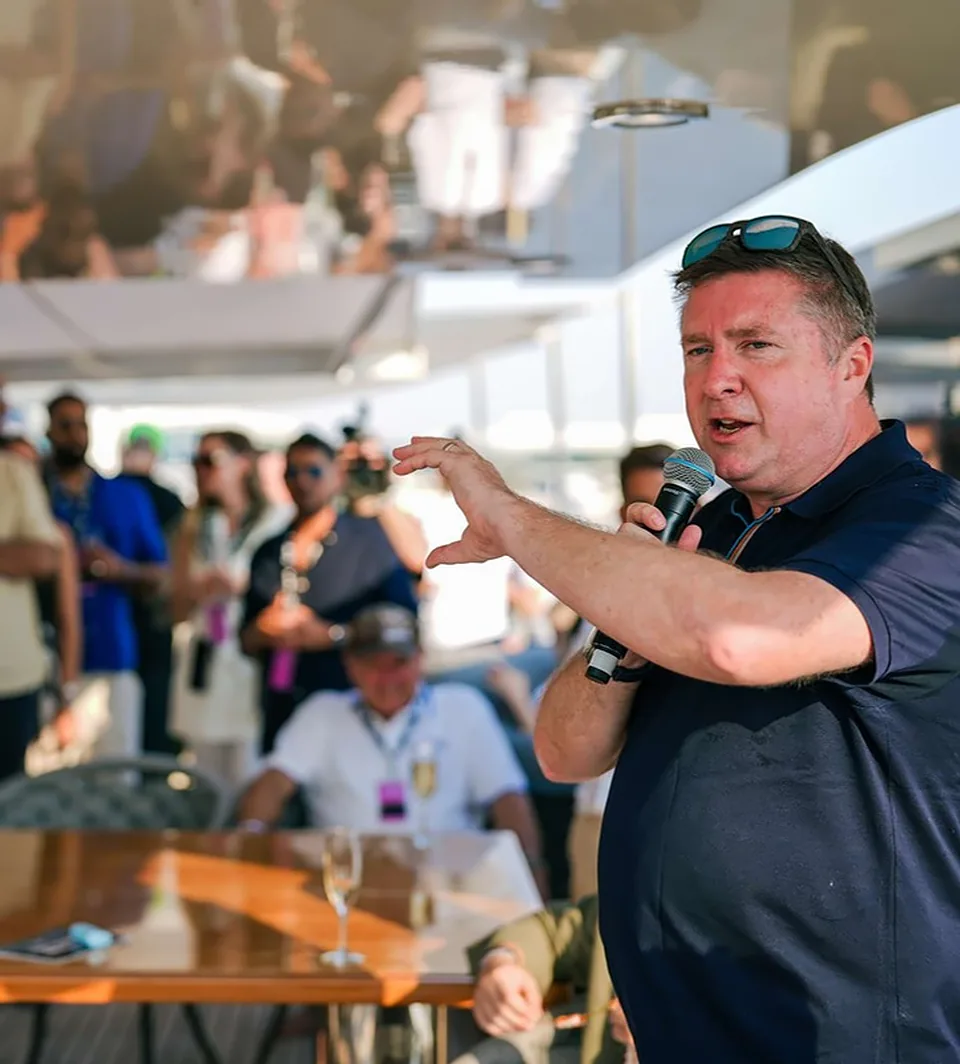 David Croft speaking into a microphone during a yacht hospitality Q&A