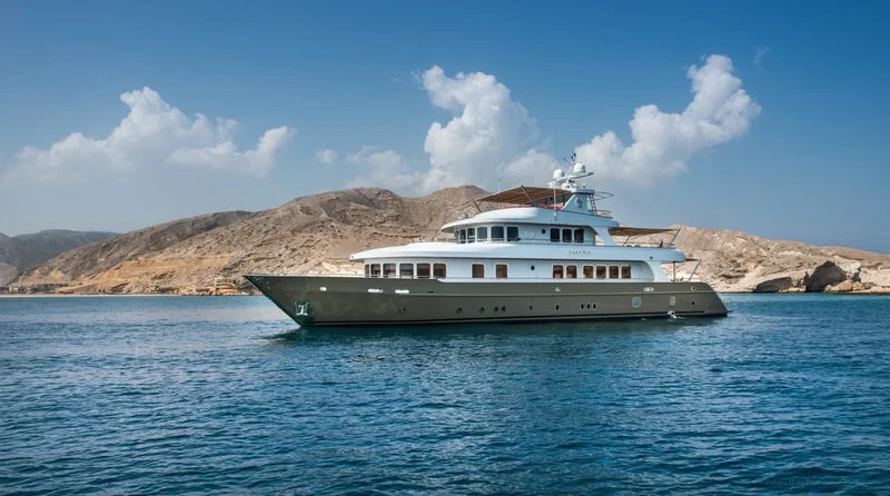 AMARA, the yacht for the shared F1 hospitality, at anchor off a rocky coastline