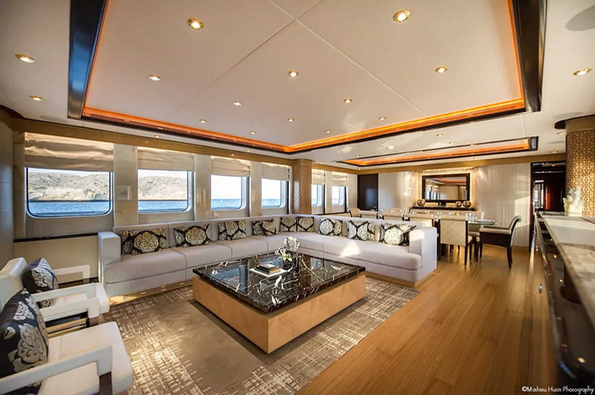 Indoor lounge aboard AMARA with sofas, a coffee table and large windows