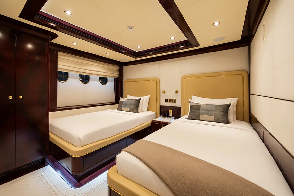 Twin cabin aboard AMARA with two single beds and porthole windows