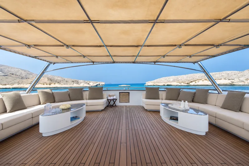 Shaded upper-deck lounge aboard AMARA with sofas and low tables