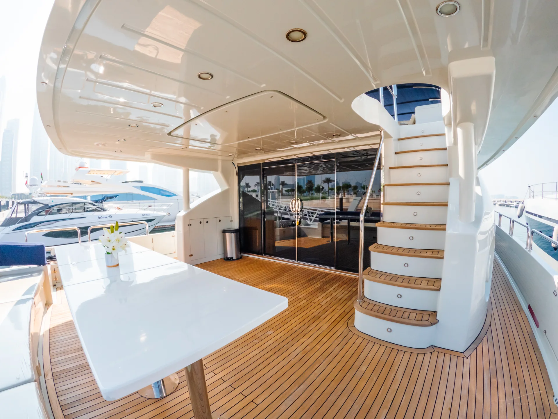 Rosso 110 aft deck with teak dining and spiral staircase