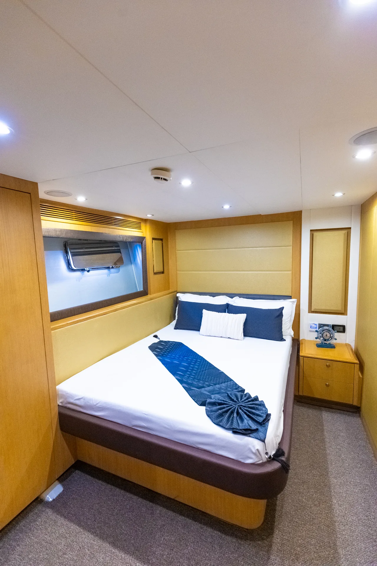 Rosso 110 guest cabin with porthole and crisp bedding
