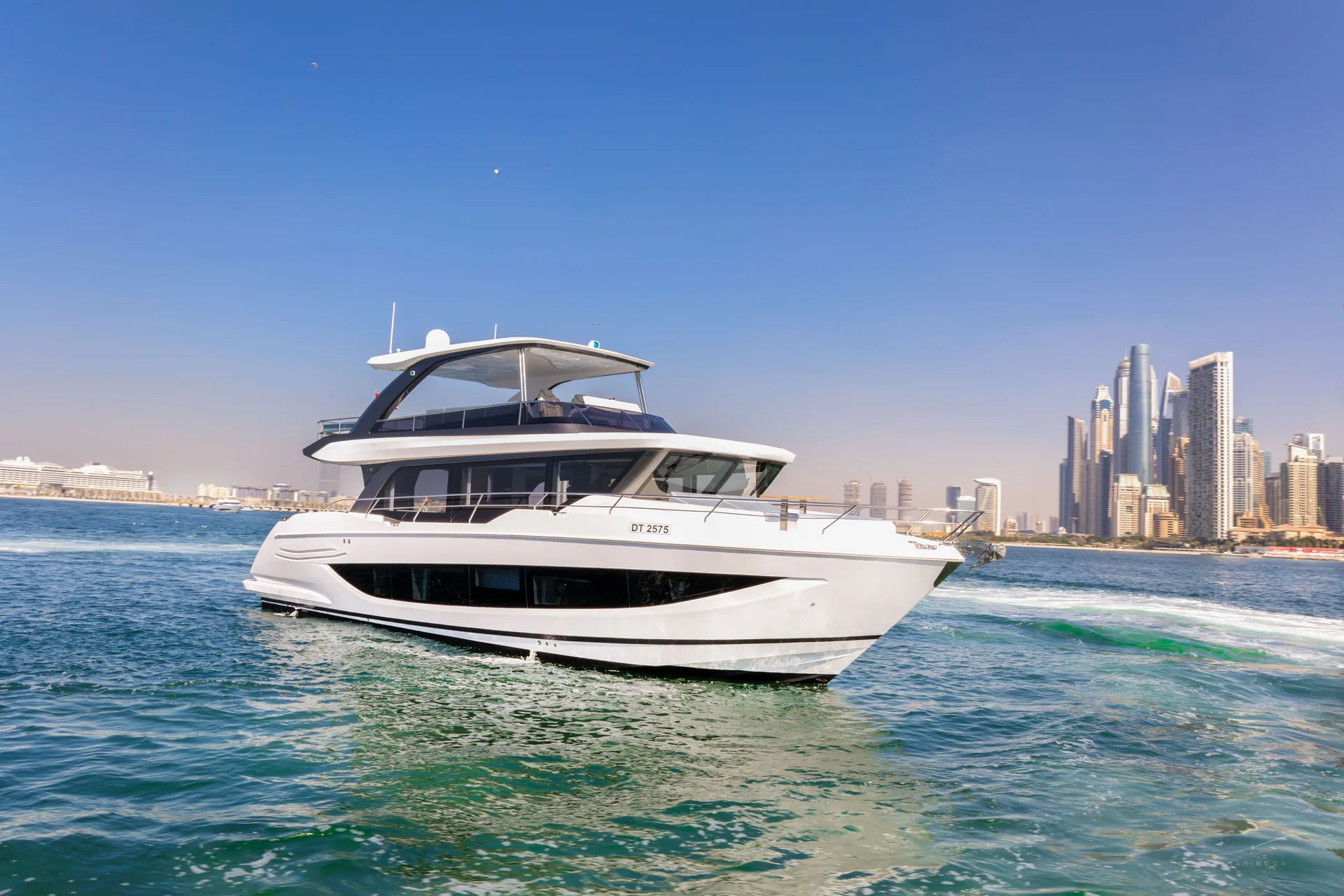 Vela 63 cruising in Dubai waters with the marina skyline
