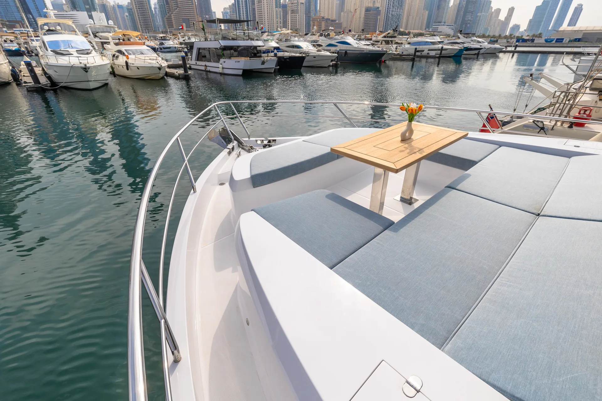 Vela 63 bow sunpad and dining table with Dubai Marina skyline
