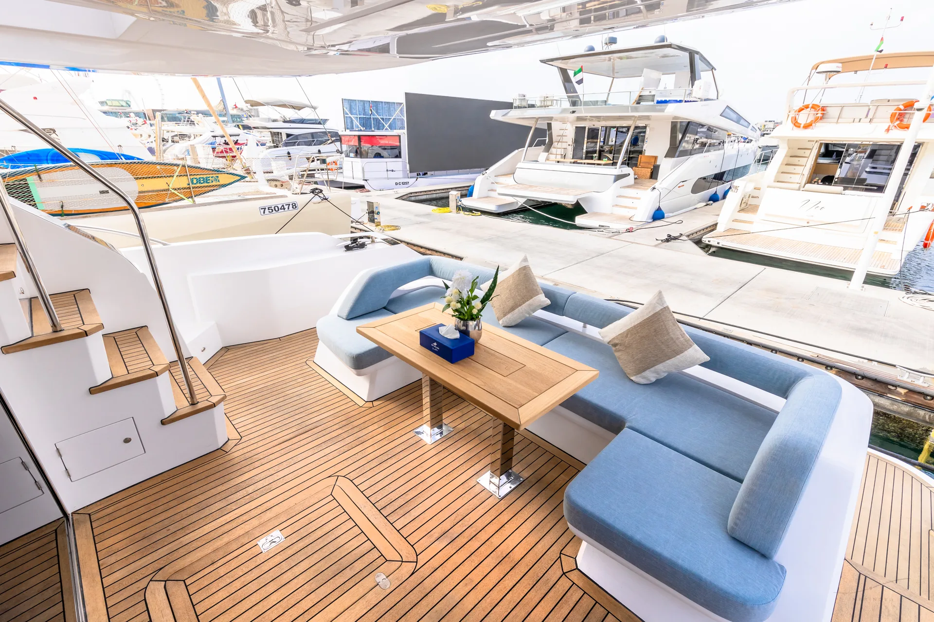 Vela 63 aft deck entertaining space with U-lounge and teak
