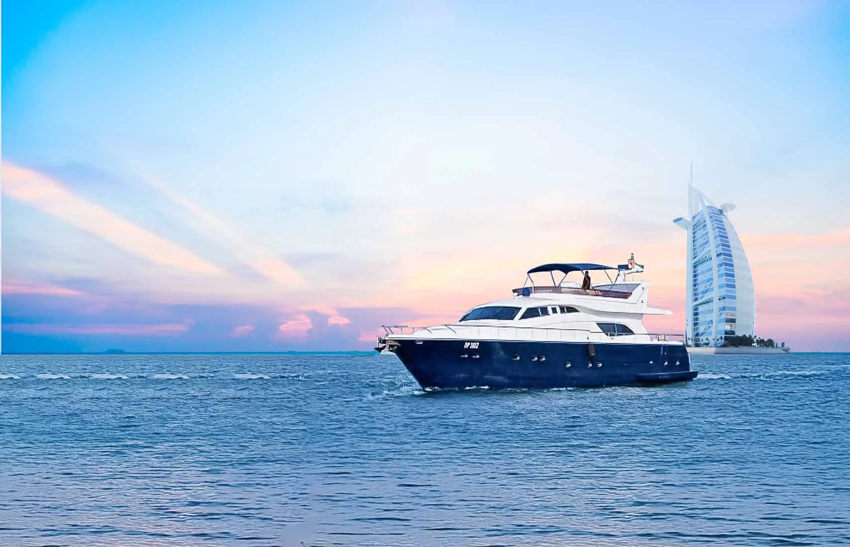 80 feet yacht rental Dubai cruising near Burj Al Arab at sunset.