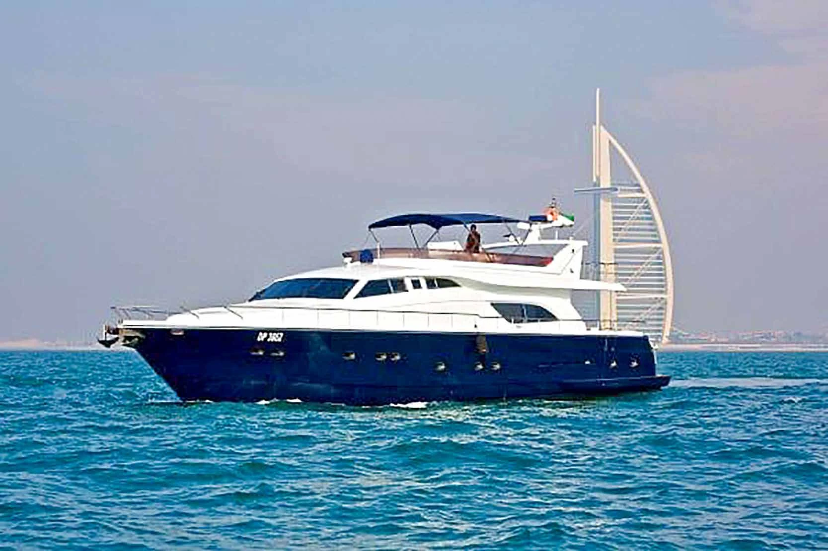 80 feet yacht rental Dubai with a dark blue hull near Burj Al Arab.