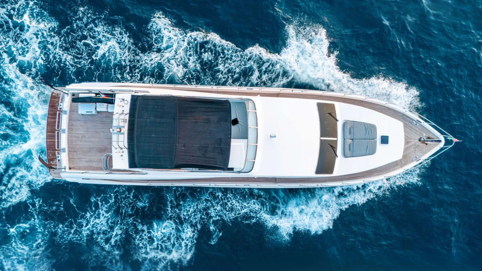 Majesty 77 yacht from directly above, side on, with its wake spreading behind.