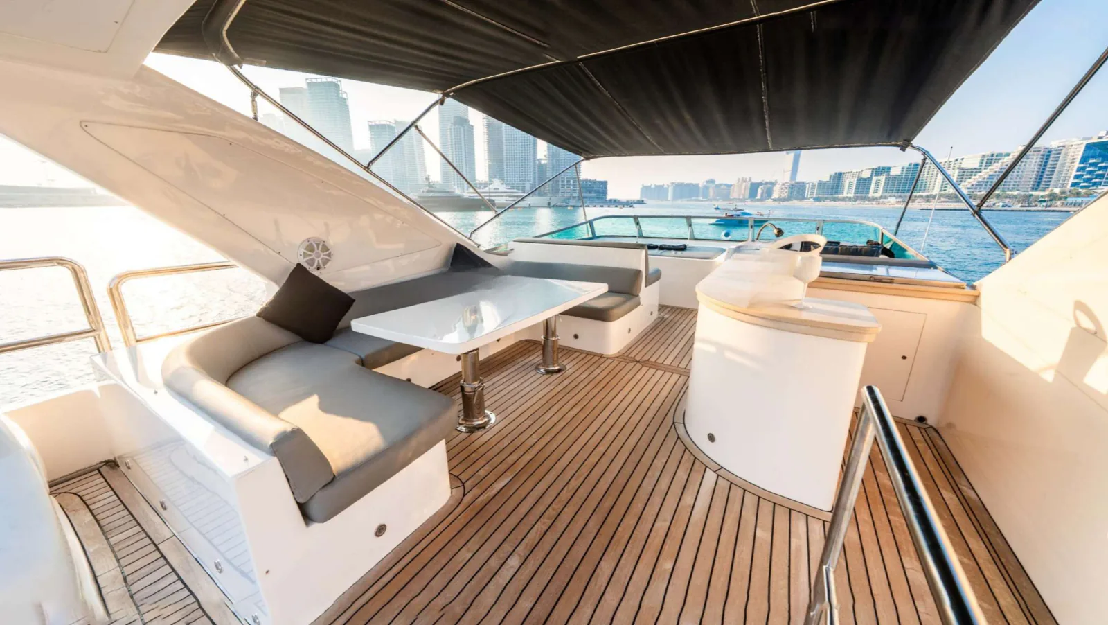 Majesty 77 yacht flybridge seating and table under a shade canopy.