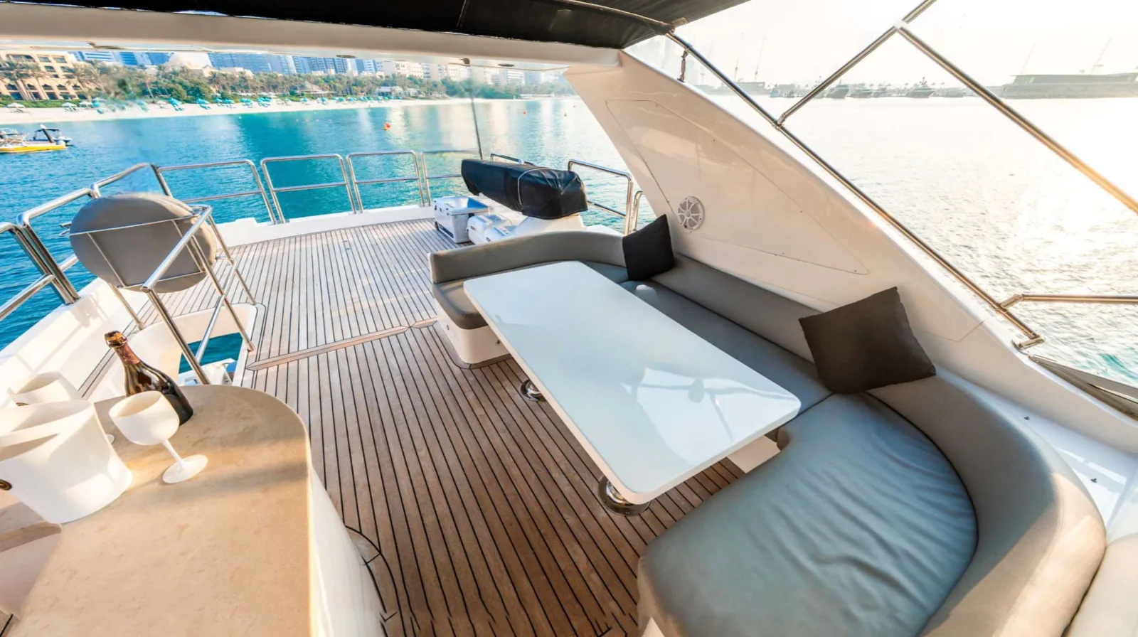 Majesty 77 yacht flybridge lounge with curved seating, a table and a bar counter.