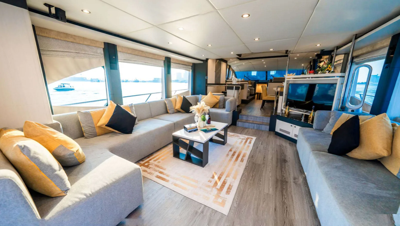 Majesty 77 yacht saloon seating beside a bar unit and a television.