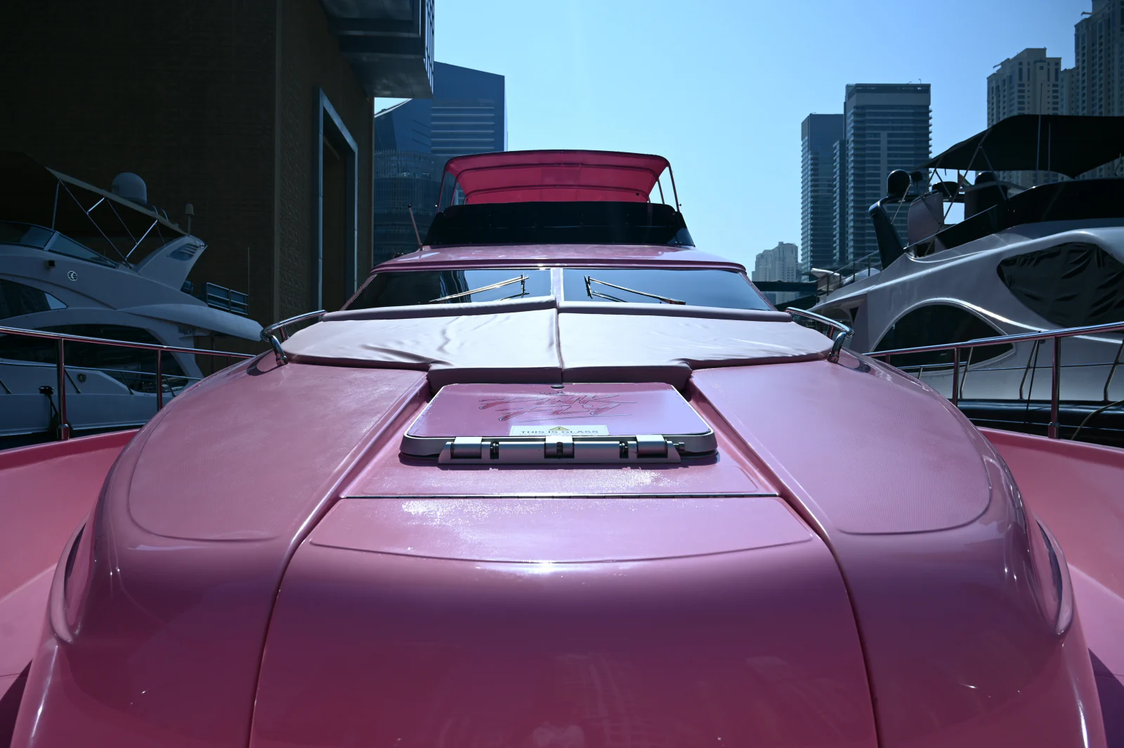 Pink yacht rental Dubai with the pink bow sunbed and marina view