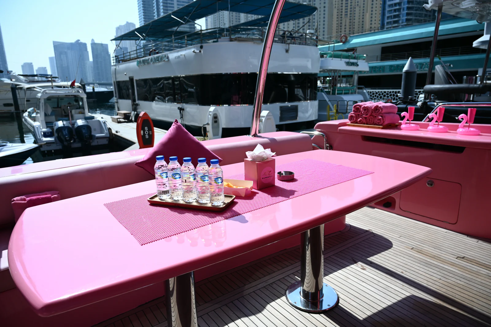 Pink yacht rental Dubai aft deck with a large pink table