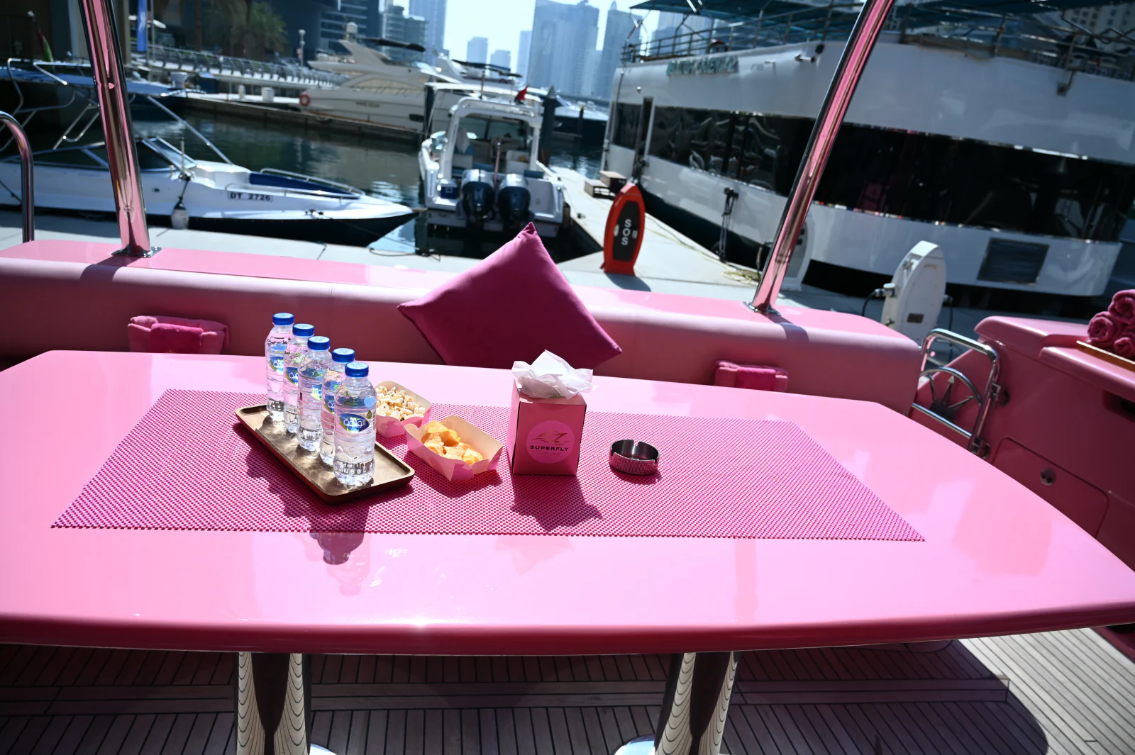 Pink yacht rental Dubai aft deck table prepared with refreshments