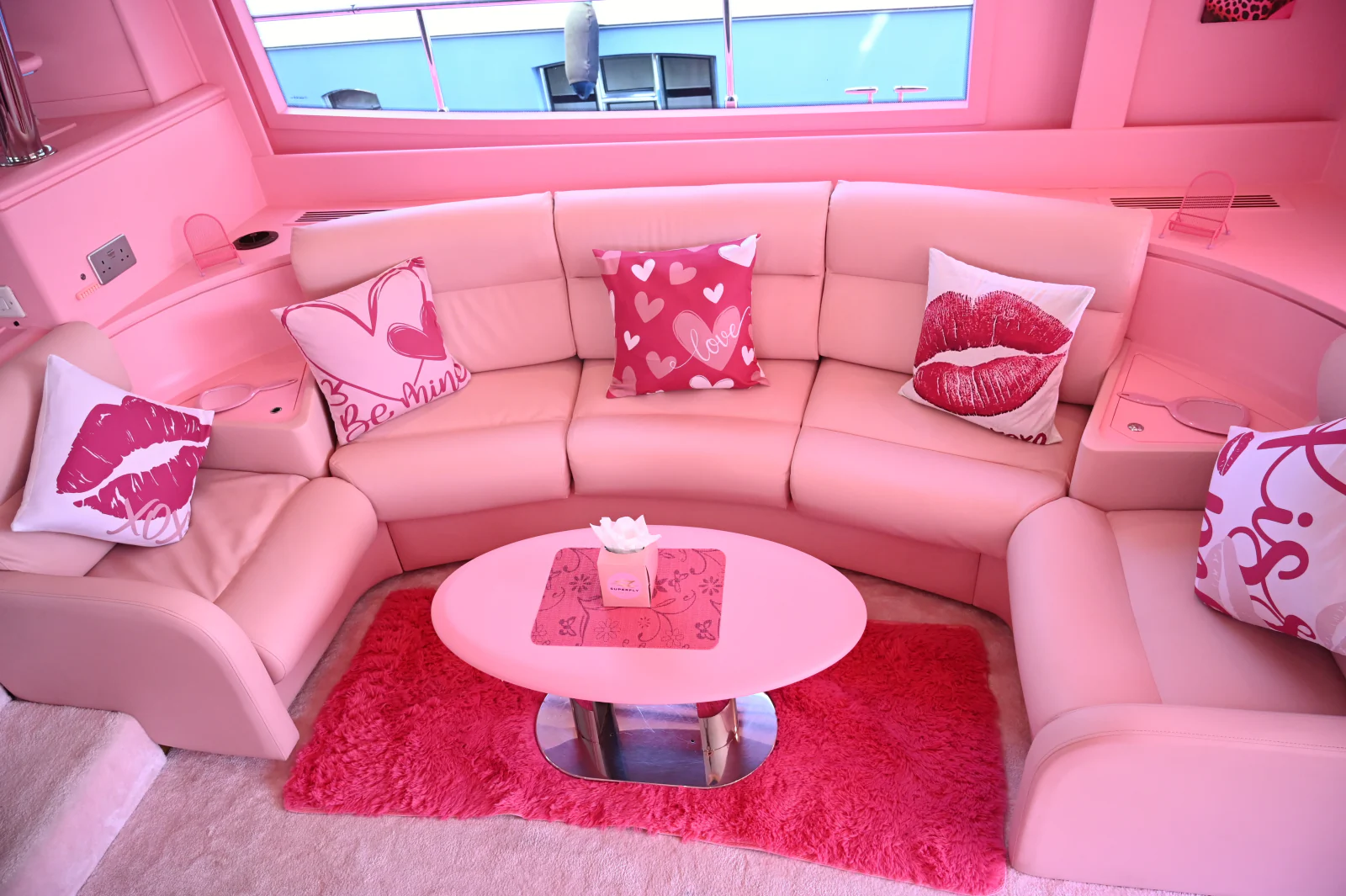 Pink yacht rental Dubai main saloon with curved pink seating