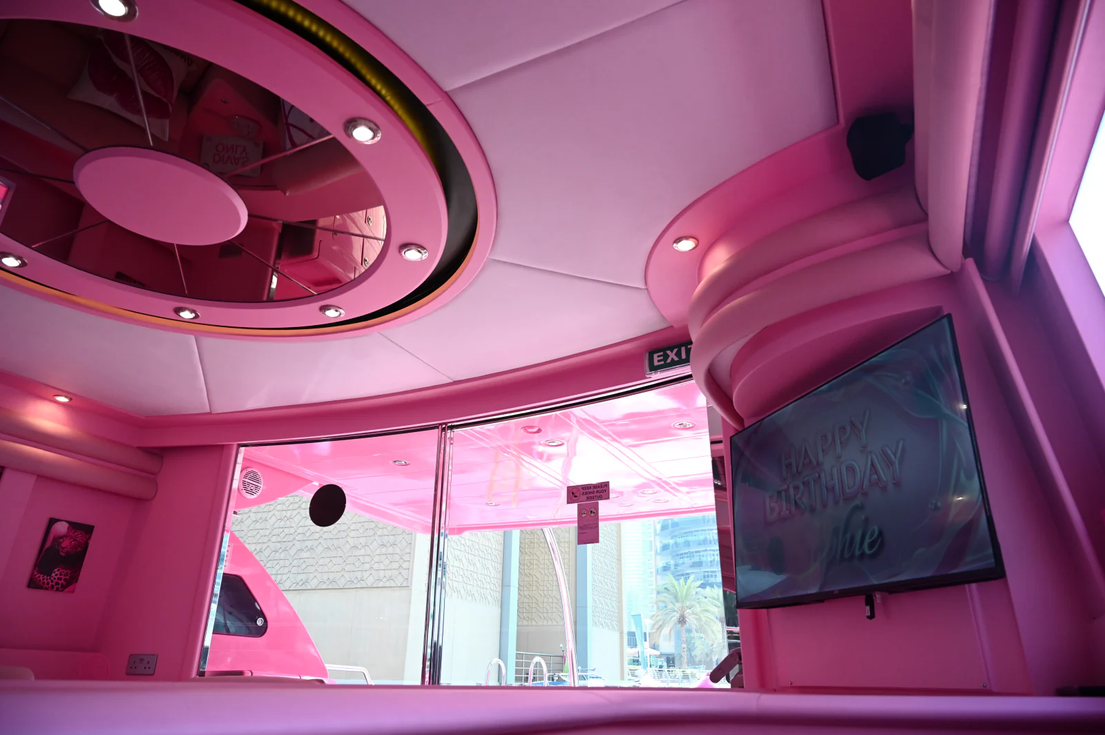 Pink yacht rental Dubai lounge with a birthday screen setup