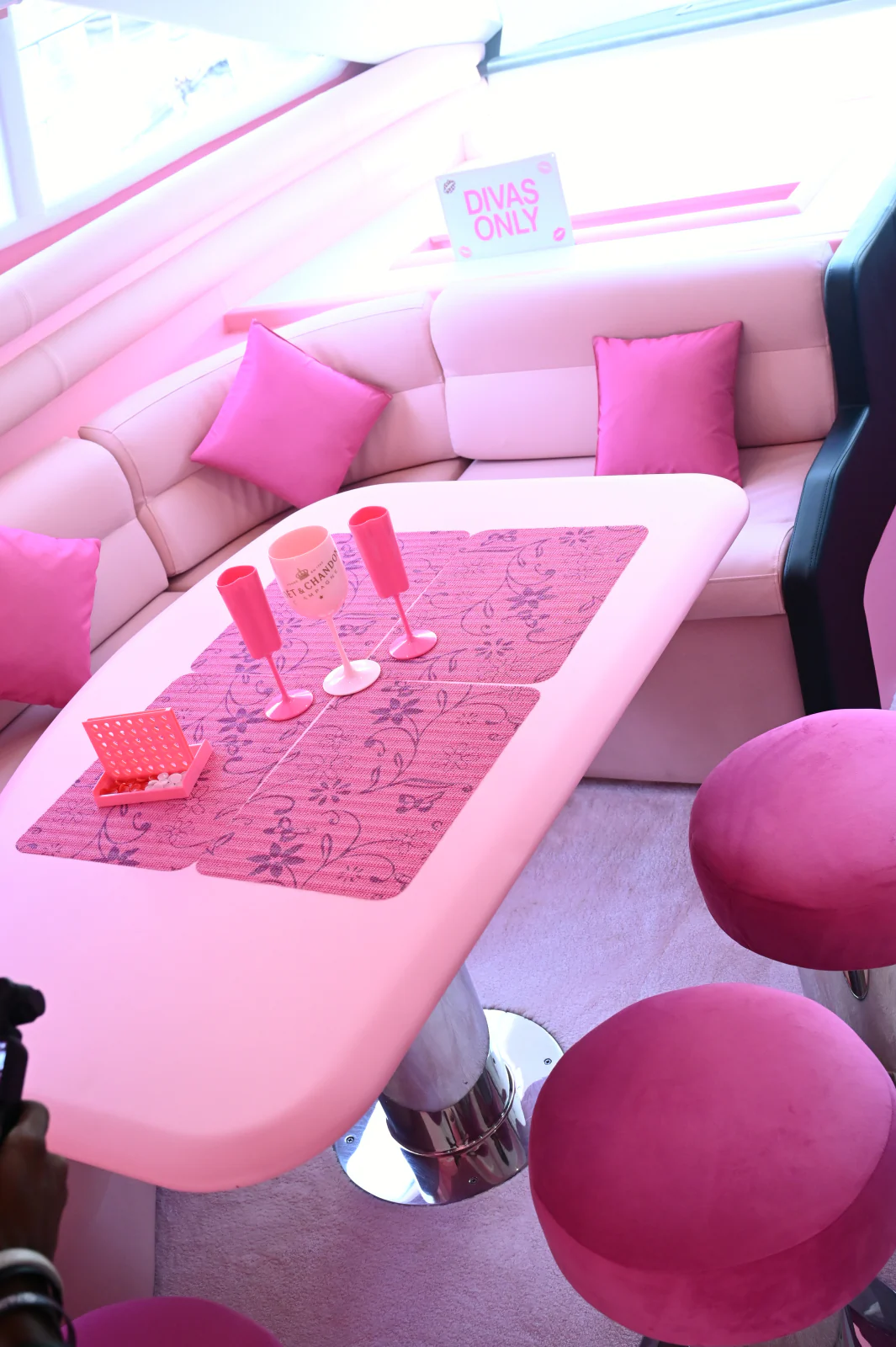 Pink yacht rental Dubai party table with pink glasses and cushions
