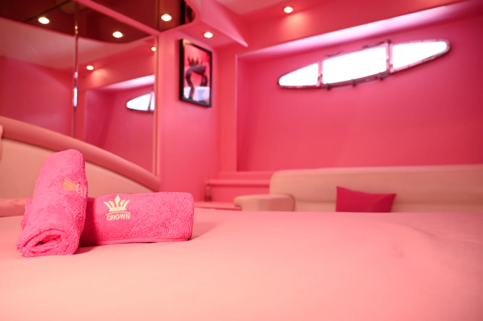 Pink yacht rental Dubai cabin detail with pink towels and wall finish