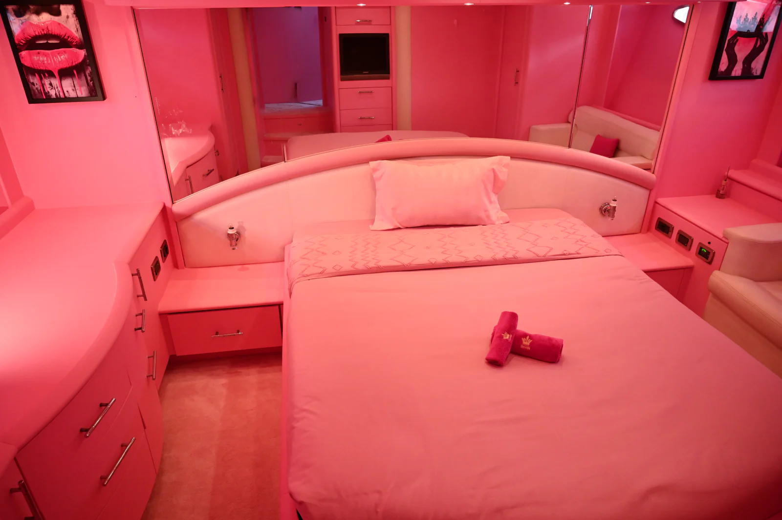 Pink yacht rental Dubai guest cabin with a double bed and pink interior